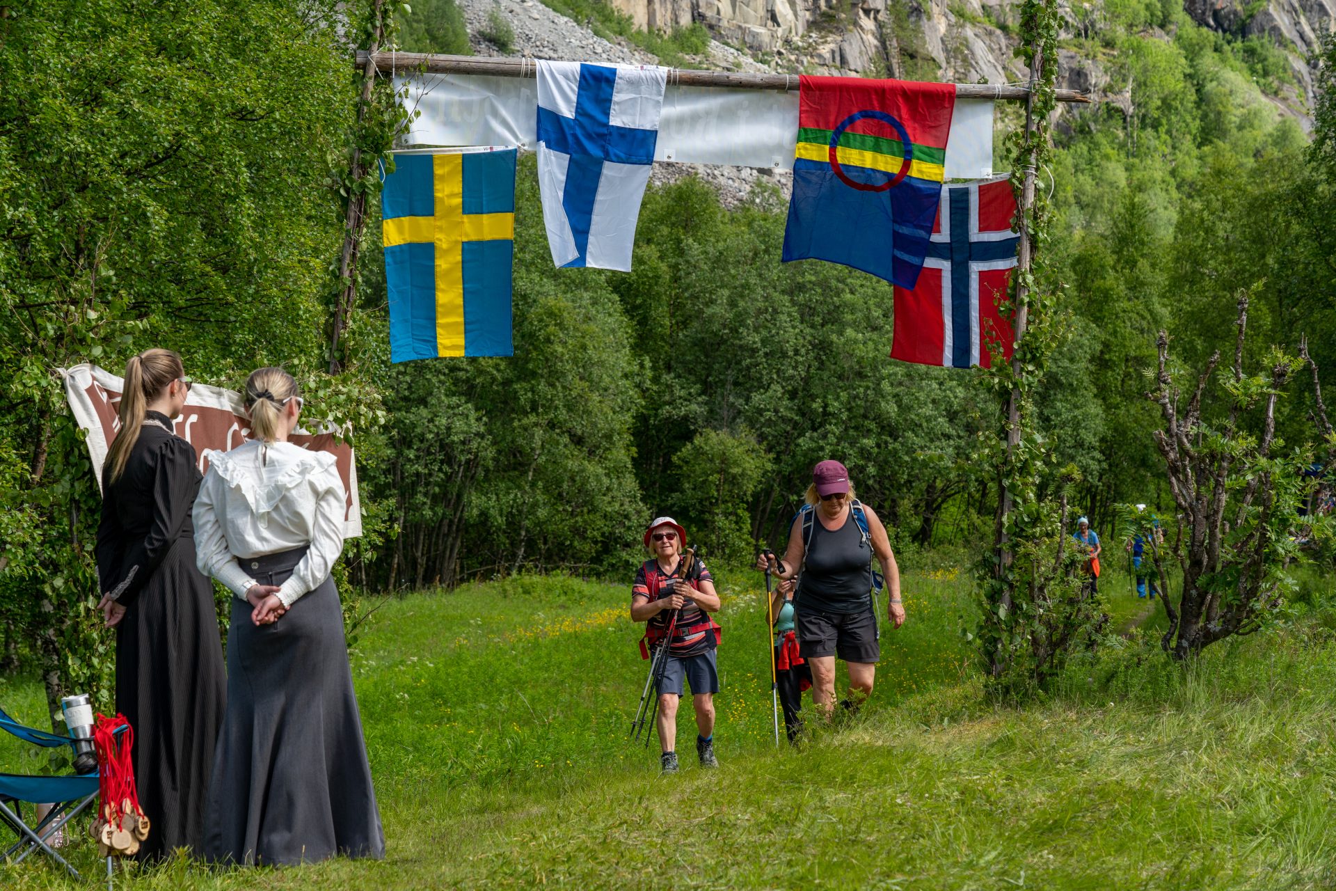 Deltakere på vei til målomårdet. Norsk, samisk svensk og finsk flagg henger over.
